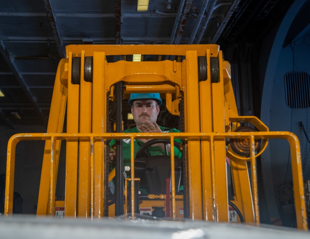 Sailor Lifts Cargo With Fork Lift