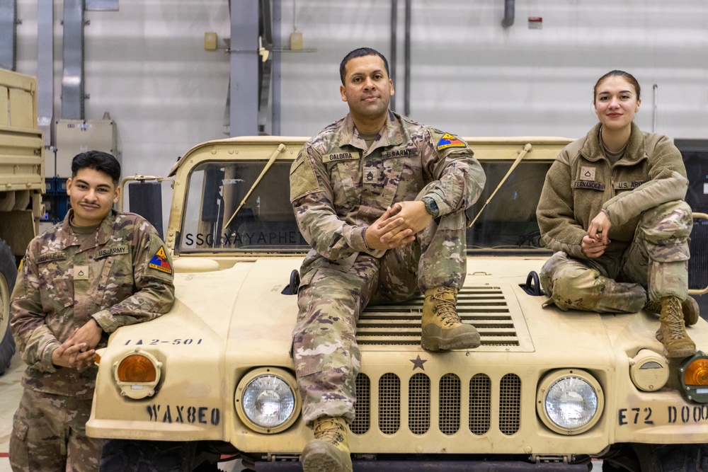 U.S. Army soldiers pose with their HMMWV during a static display