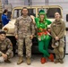 U.S. Army Soldiers pose with one of Santa's Elves during a holiday party