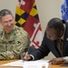 Col. Christopher Nyland, Fort Meade commander, looks on as Dr. Calvin Ball, Howard County Executive, signs a Fort George G. Meade and Howard County Intergovernmental Support Agreement document