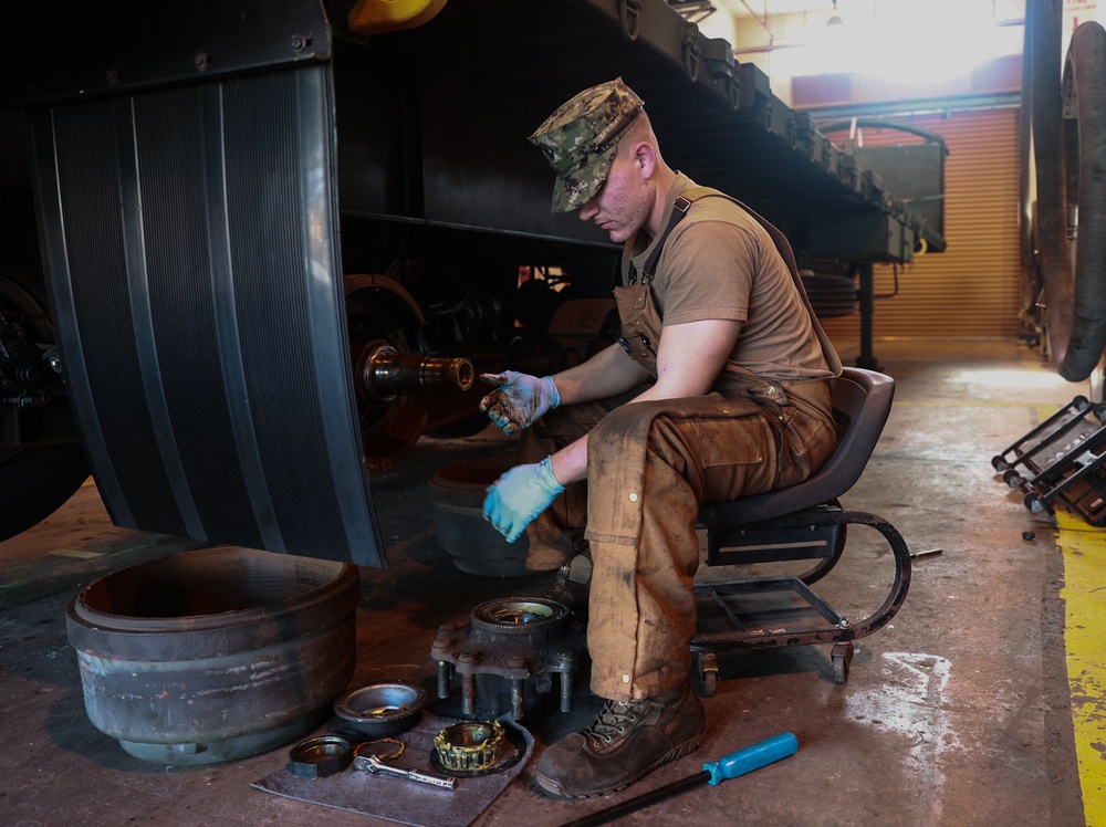 Construction Mechanic 3rd Class Scott Lyons maintains a piece of Civil Engineering Support Equipment (CESE).