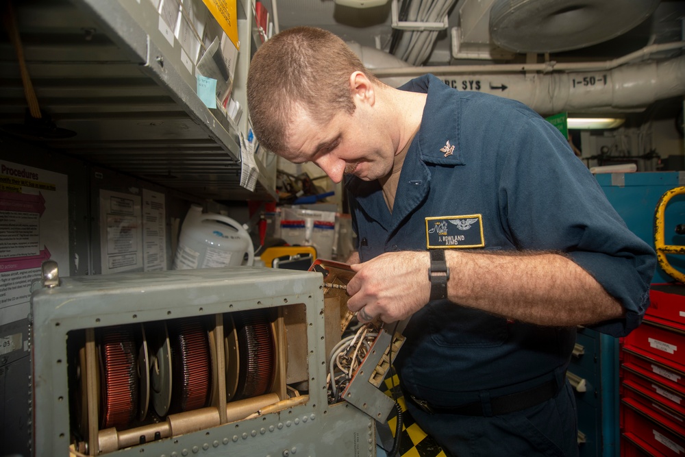 Sailor Inspects Damaged Generator Assembly