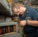 Sailor Inspects Damaged Generator Assembly