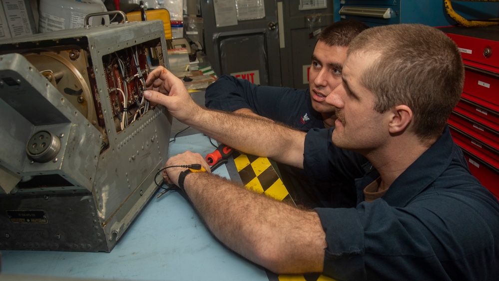 Sailor Inspects Damaged Generator Assembly