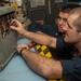 Sailor Inspects Damaged Generator Assembly