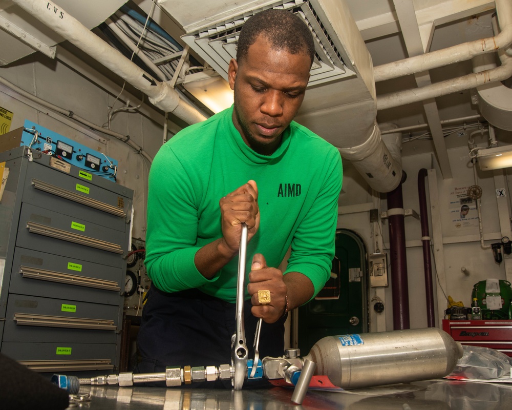 Sailor Attaches Hose To Oxygen Sample Bottle