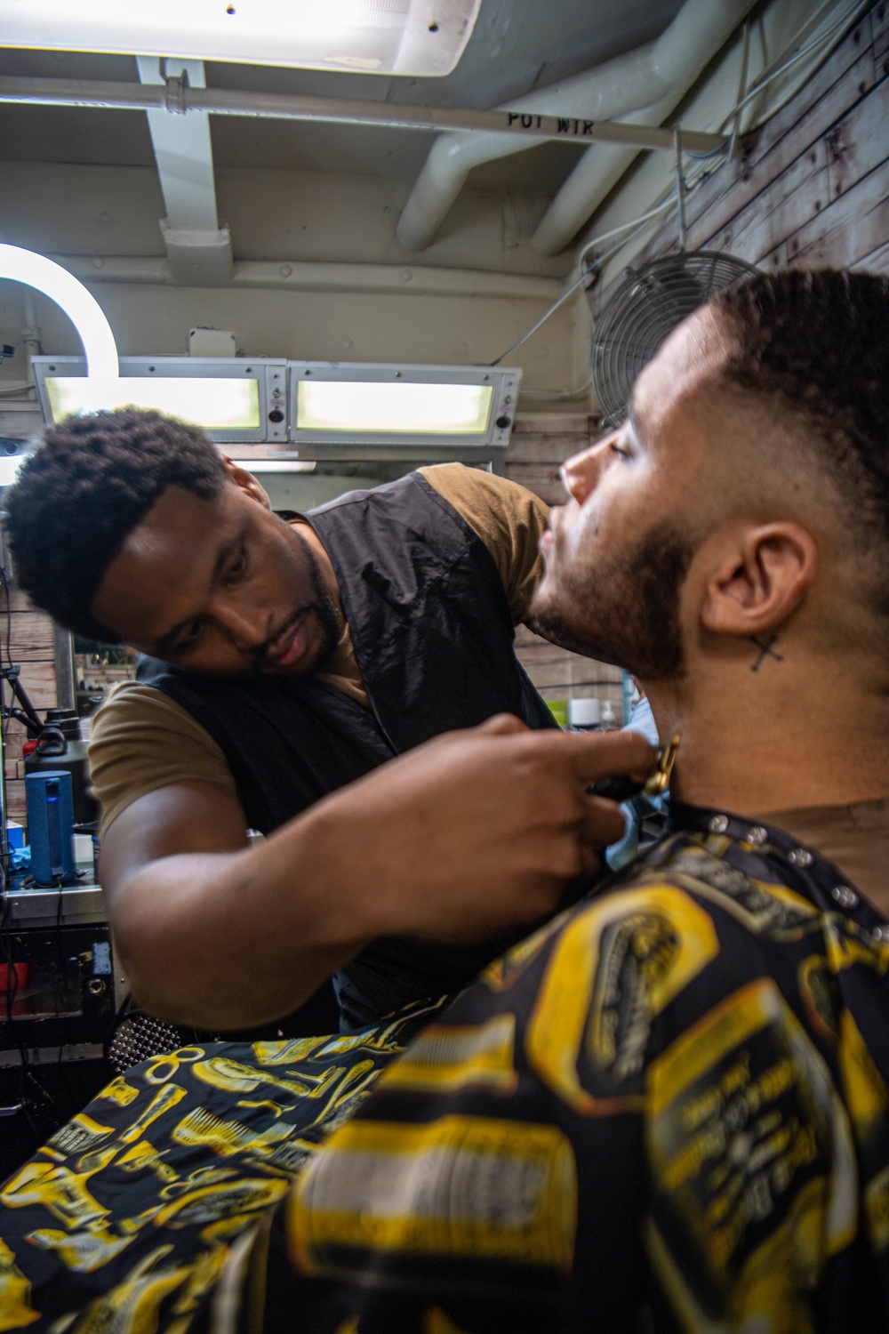 A student with Officer Candidate School (OCS) Class 20-07 receives his  first Navy haircut from Pamela Pendergrast, a barber with the Navy Exchange  on board Naval Air Station (NAS) Pensacola. - PICRYL -