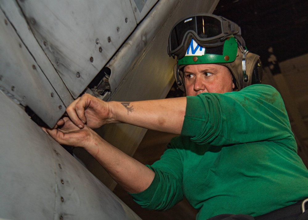 Sailor Installs A Panel On An Aircraft