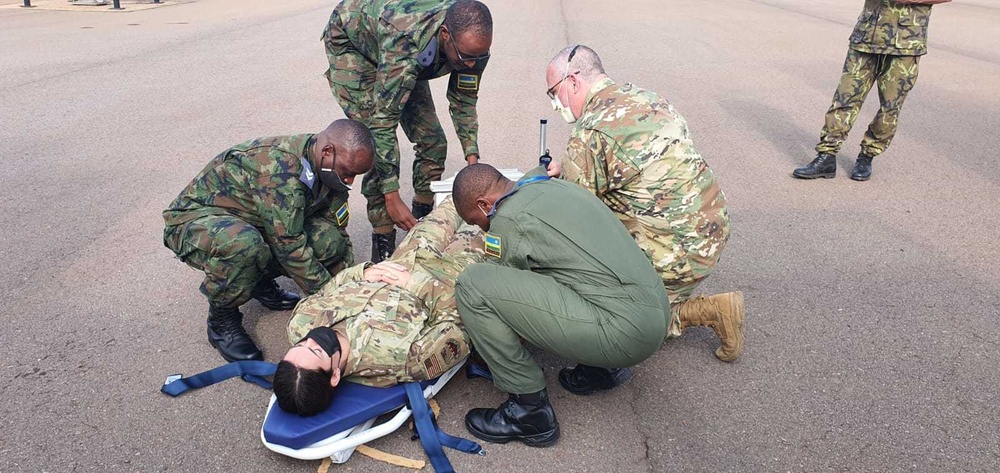 Airmen collaborate with Rwandan Armed Forces in an exercise to load simulated patients onto an aircraft for UN deployment