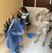 Airmen assist Senegalese Armed Forces with the sequence for putting on and taking off personal protective equipment