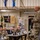 A U.S. Army officer in OCP (Operational Camouflage Pattern) uniform stands and addresses a group of seated military personnel and at least one civilian during what appears to be a formal briefing or training session. The setting is an indoor military facility decorated with unit guidons, flags, and Army program banners. The session appears focused on topics including diversity, accountability, and SHARP (Sexual Harassment/Assault Response and Prevention).