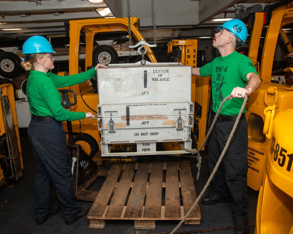 Sailors Stabilize Cargo During Hoist Operations