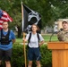 Airman holds flags during POW/ MIA ruck marxh