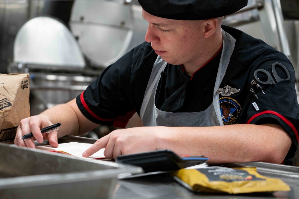 USS Carl Vinson (CVN-70) Sailor Prepares For Meal