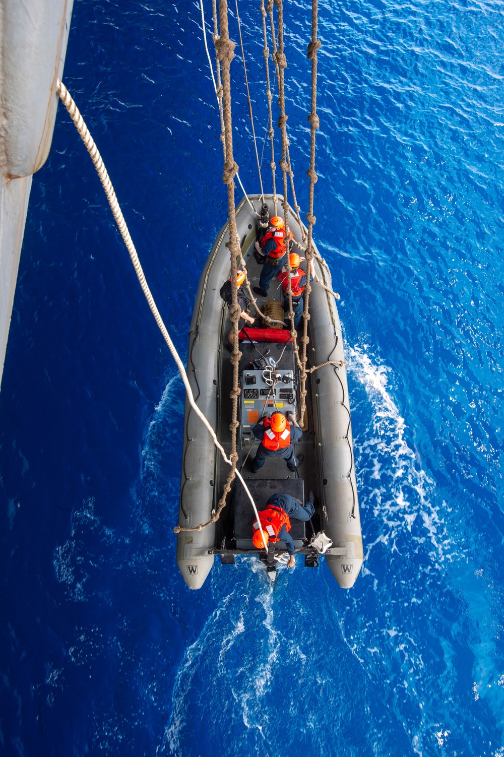 U.S. Navy Sailors Lower A Rigid Hull Inflatable Boat