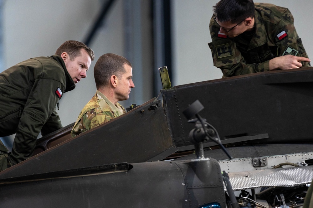 U.S Army Soldier shows Polish Military the inside of a AH-64 Apache
