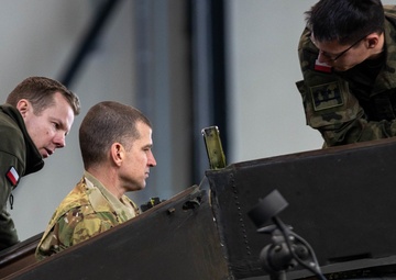 U.S Army Soldier shows Polish Military the inside of a AH-64 Apache