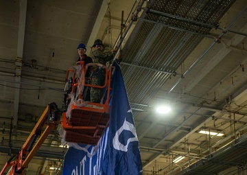 USS Ronald Reagan (CVN 76) Sailors hang banner in the hangar bay