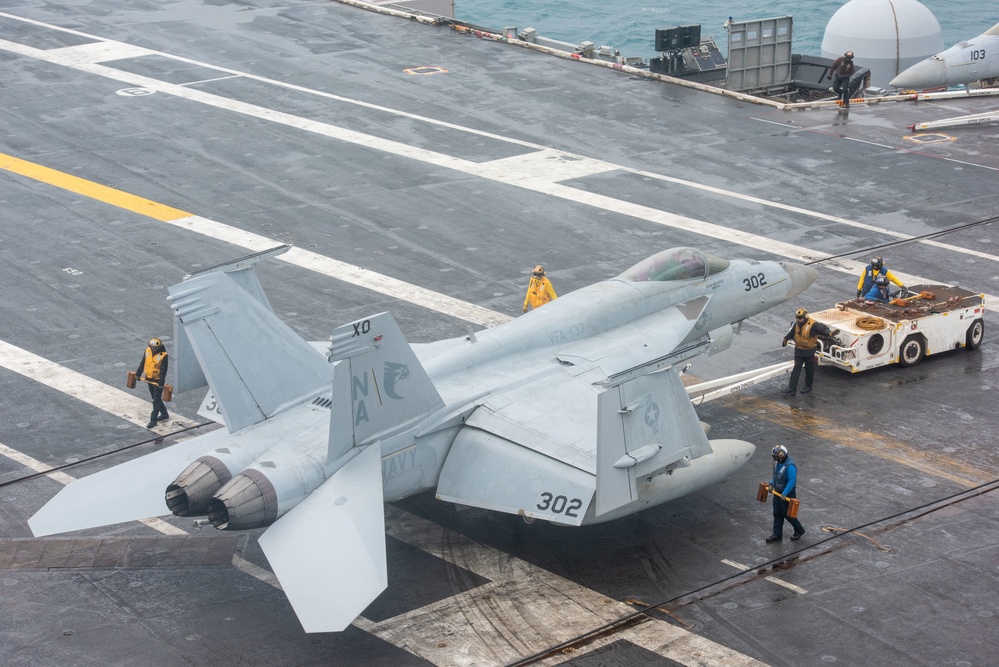 Sailor Tow An F/A-18E Super Hornet On The Flight Deck