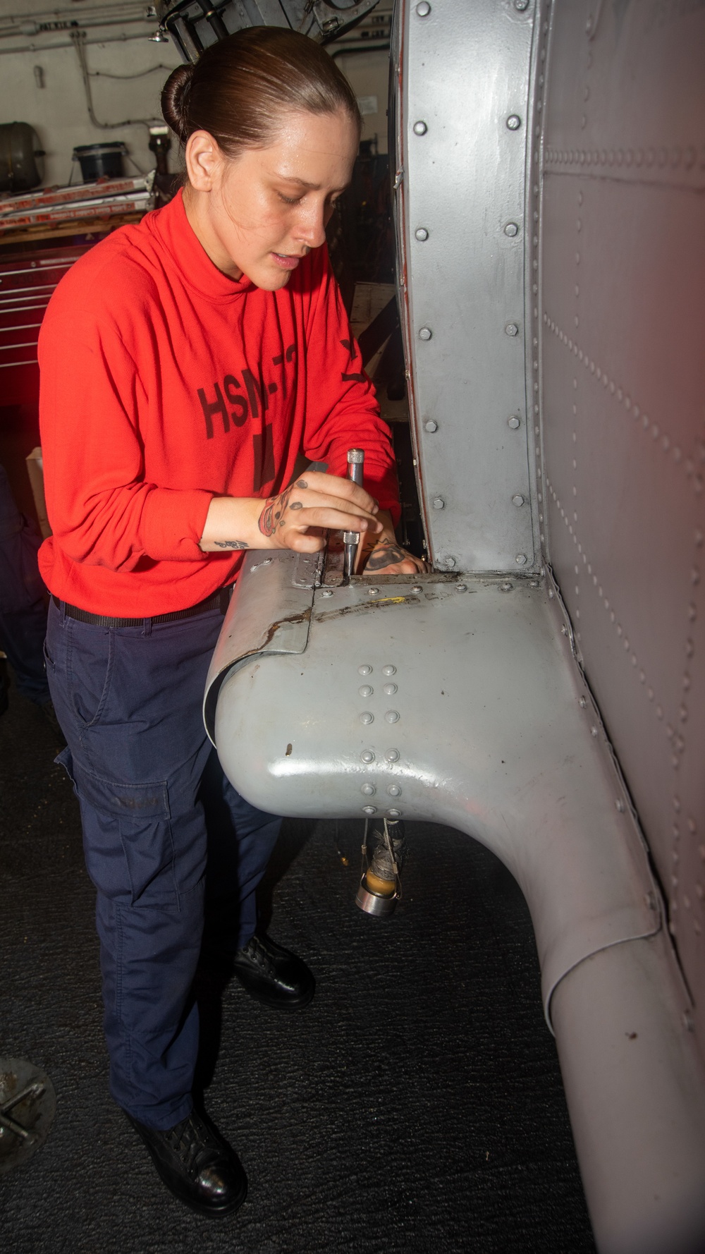 Sailor Removes Bomb Rack Unit From Helicopter