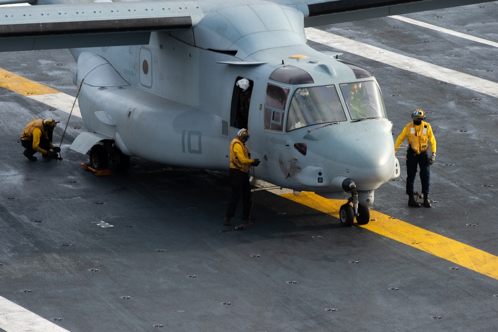 U.S. Navy Sailors Chain Down An Osprey