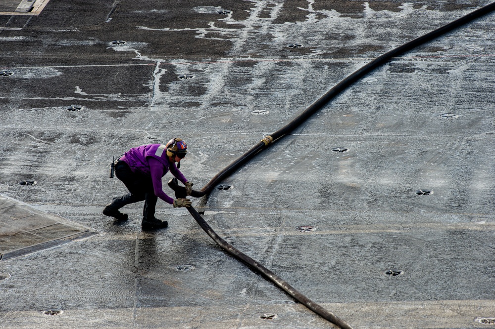 U.S. Navy Sailor Removes Kink From JP-5 Hose