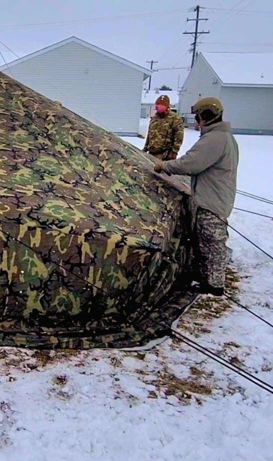 Airmen learn to build Arctic 10-person tents during cold-weather training at Fort McCoy