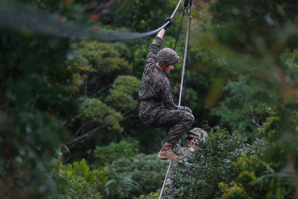 Marine helps fellow trainee return to the 2 strand bridge during the E-cores at Jungle Warfare Training Center.