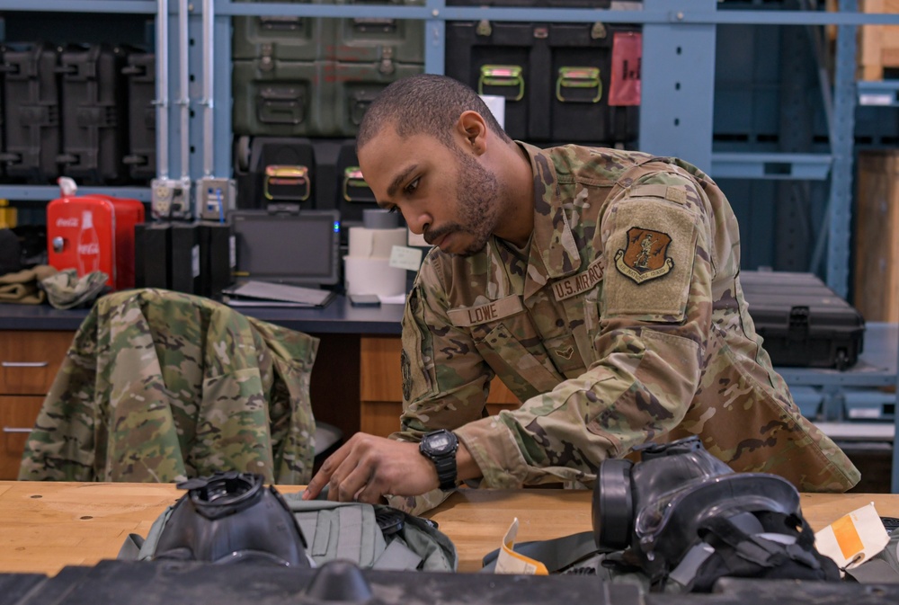Airman 1st Class Able Lowe prepares gas masks for deployment
