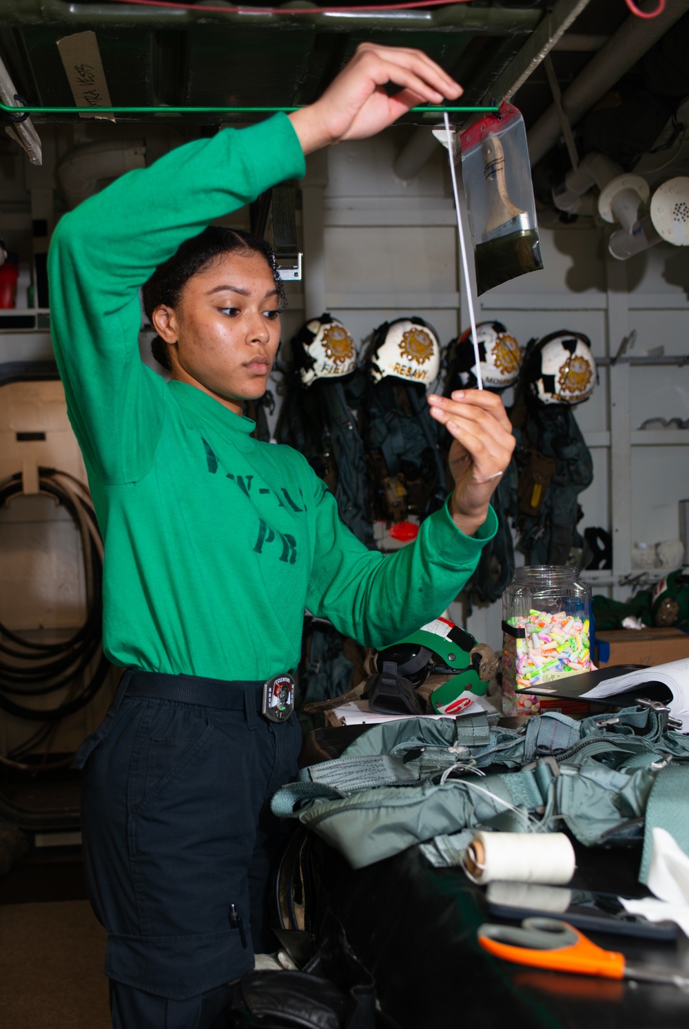 Sailor Inspects A Parachute Harness