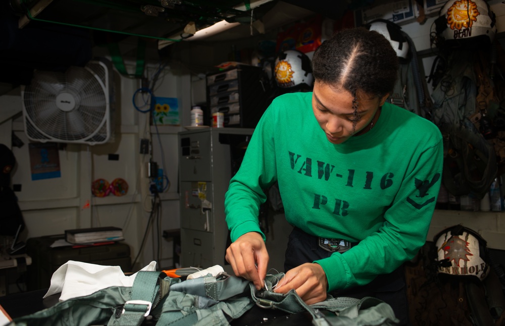 Sailor Inspects A Parachute Harness