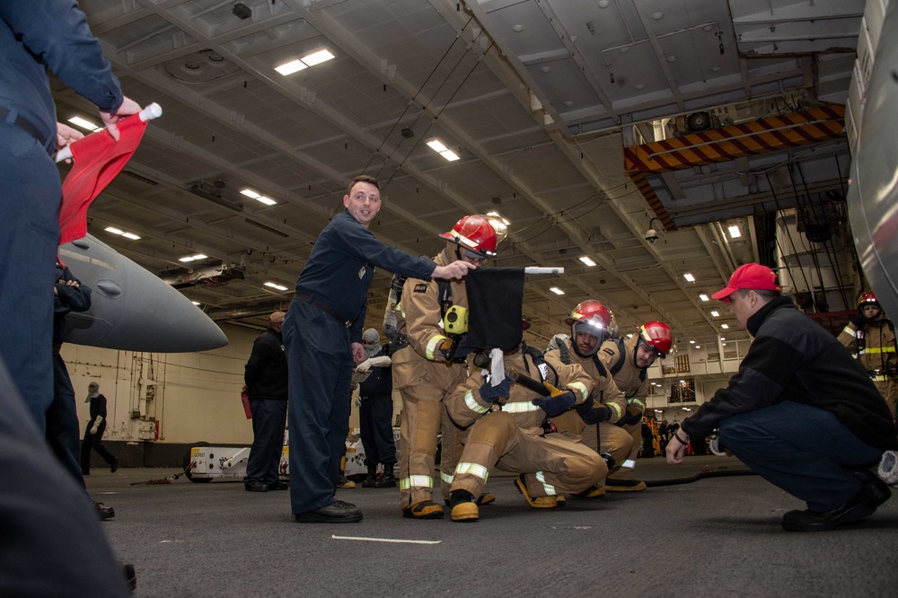 Sailors simulate a fire casualty during a general quarters drill