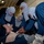 Sailors perform stretcher bearer tactics on a simulated patient during a general quarters drill.