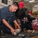 Sailors perform maintenance on an air compressor