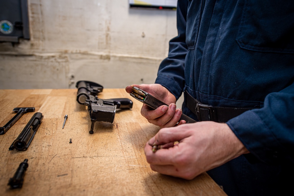 Sailor reloads a magazine for an M16 rifle