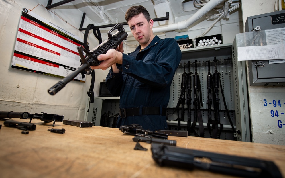 Sailor conducts a function check on an M16 rifle