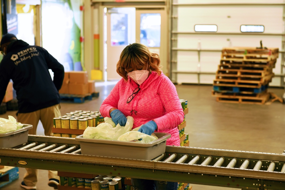 Sherrilyne Marshall, civilian champion of CNIC Women’s Resource Group (ERG), prepares bags to be filled on the assembly line at the Capital Area Food Bank during a community outreach event