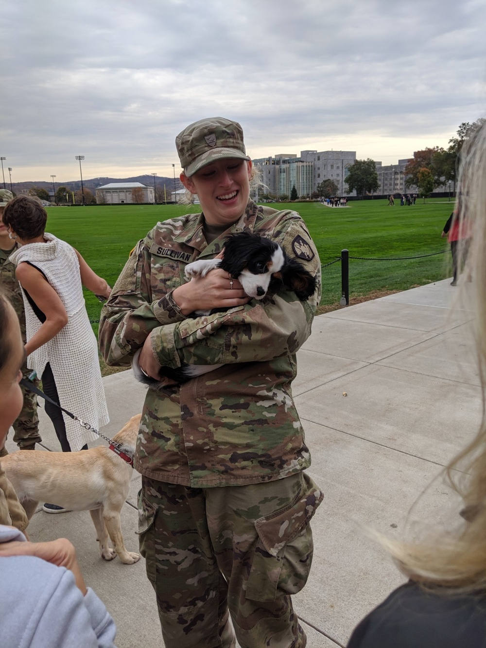 A US Military Academy Cadet cradles a therapy dog during a support event on West Point