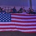 Team Tobyhanna employees and famil members unfurl flag for Star-Spangled Banner