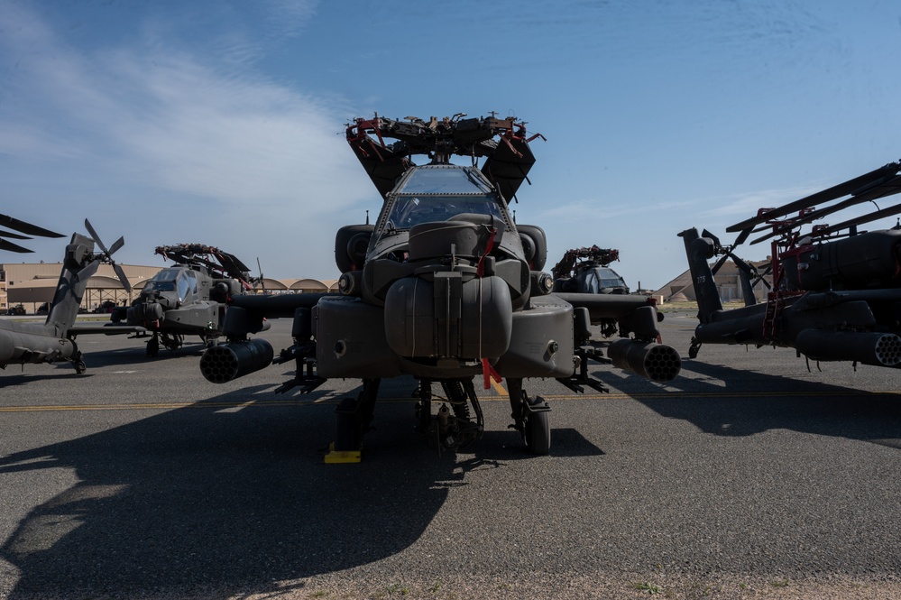 AH-64 Apaches sit on the flight line waiting for processing.