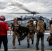 U.S. Navy Sailors Unload Gear From A Helicopter