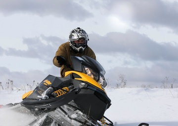 U.S. Navy Explosive Ordnance Disposal Technician Drives a Snowmobile