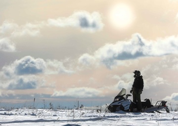 U.S. Navy Explosive Ordnance Disposal Technician Drives a Snowmobile