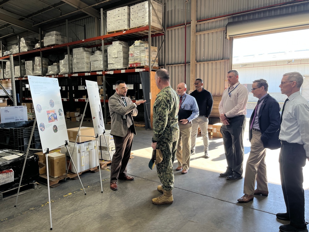 Steven Burrill, NBC 5G smart warehouse logistics program lead, NAVSUP Fleet Logistics Center San Diego, briefs Capt. David Carnal, commanding officer, NAVSUP Business Systems Center, during a visit to the area, Feb 6.