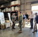 Steven Burrill, NBC 5G smart warehouse logistics program lead, NAVSUP Fleet Logistics Center San Diego, briefs Capt. David Carnal, commanding officer, NAVSUP Business Systems Center, during a visit to the area, Feb 6.