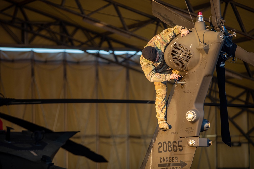 U.S. Army Soldier preforms pre-flight maintenance for upcoming mission