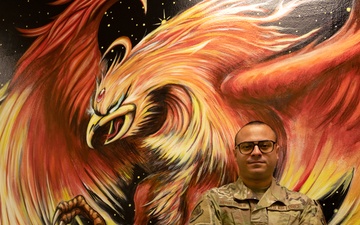 Airman 1st Class Alvin Auffant, hand-paints mural representing squadron resilience in achieving initial operating capability