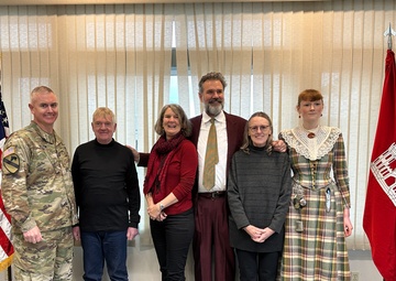 The Beeman family pose for a picture with district commander Col. Helton at the christening ceremony for survey vessel Beeman.