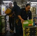 Sailors Move Supplies In a Working Party Aboard USS Oakland
