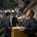 Sailors Move Supplies In a Working Party Aboard USS Oakland